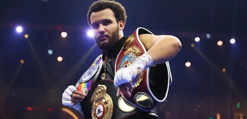 Boxeur montrant ses ceintures de champion sur scène