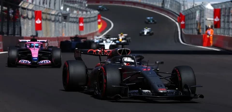 Voiture de course en tête sur circuit, autres derrière