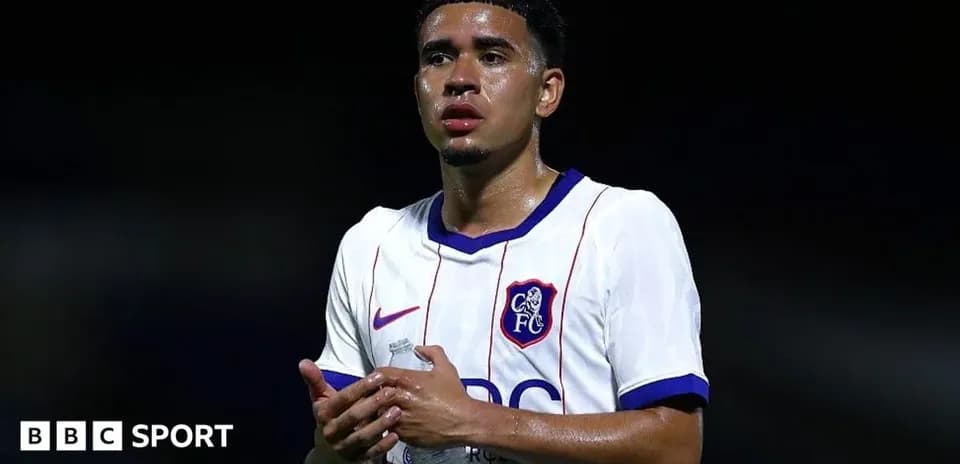 Joueur de football en tenue, tenant une bouteille d'eau