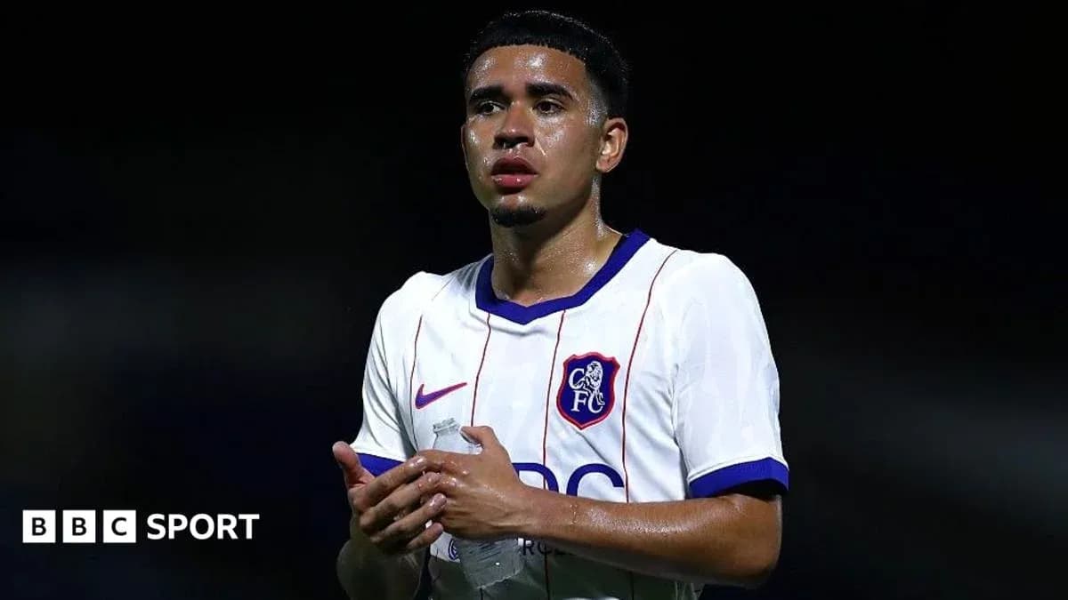 Joueur de football en tenue, tenant une bouteille d'eau