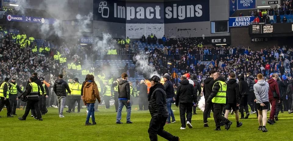 Supporters on the pitch after match disturbance