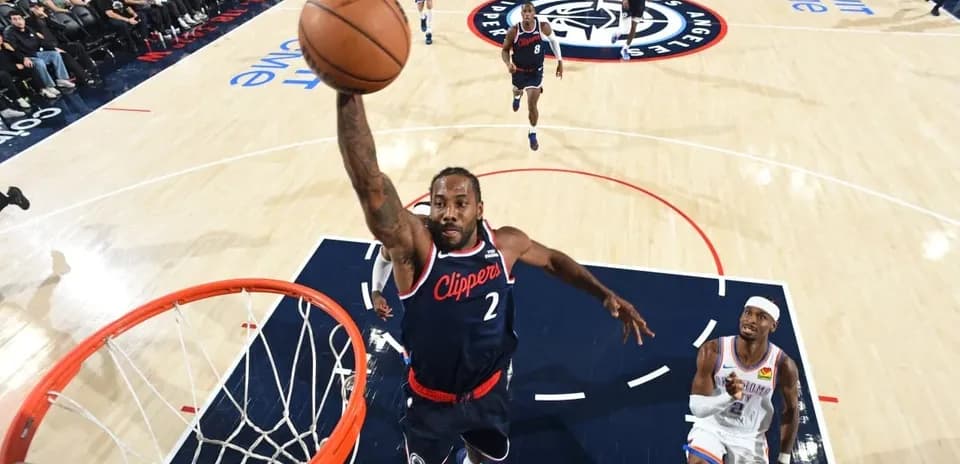 Joueur des Clippers dunkant au-dessus d'un adversaire