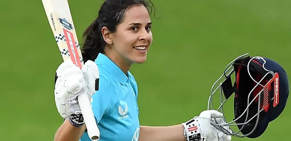 Joueuse de cricket levant sa batte après un score