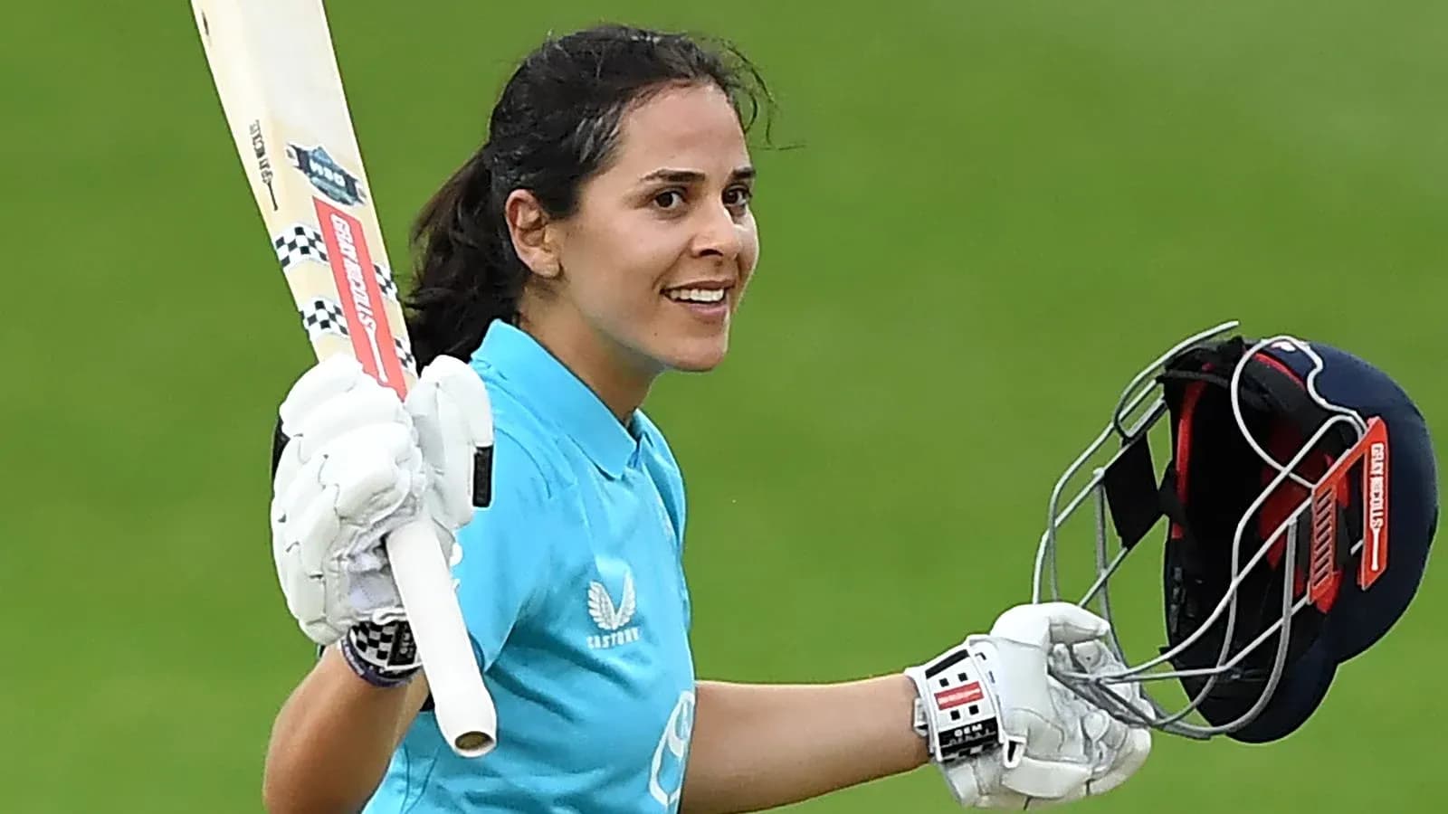 Joueuse de cricket levant sa batte après un score