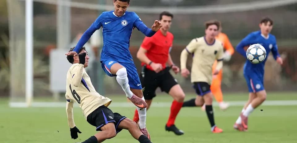 Joueur Chelsea dribblant un adversaire au sol