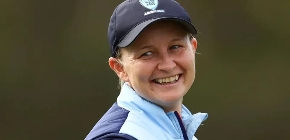 Femme souriante portant une casquette de cricket