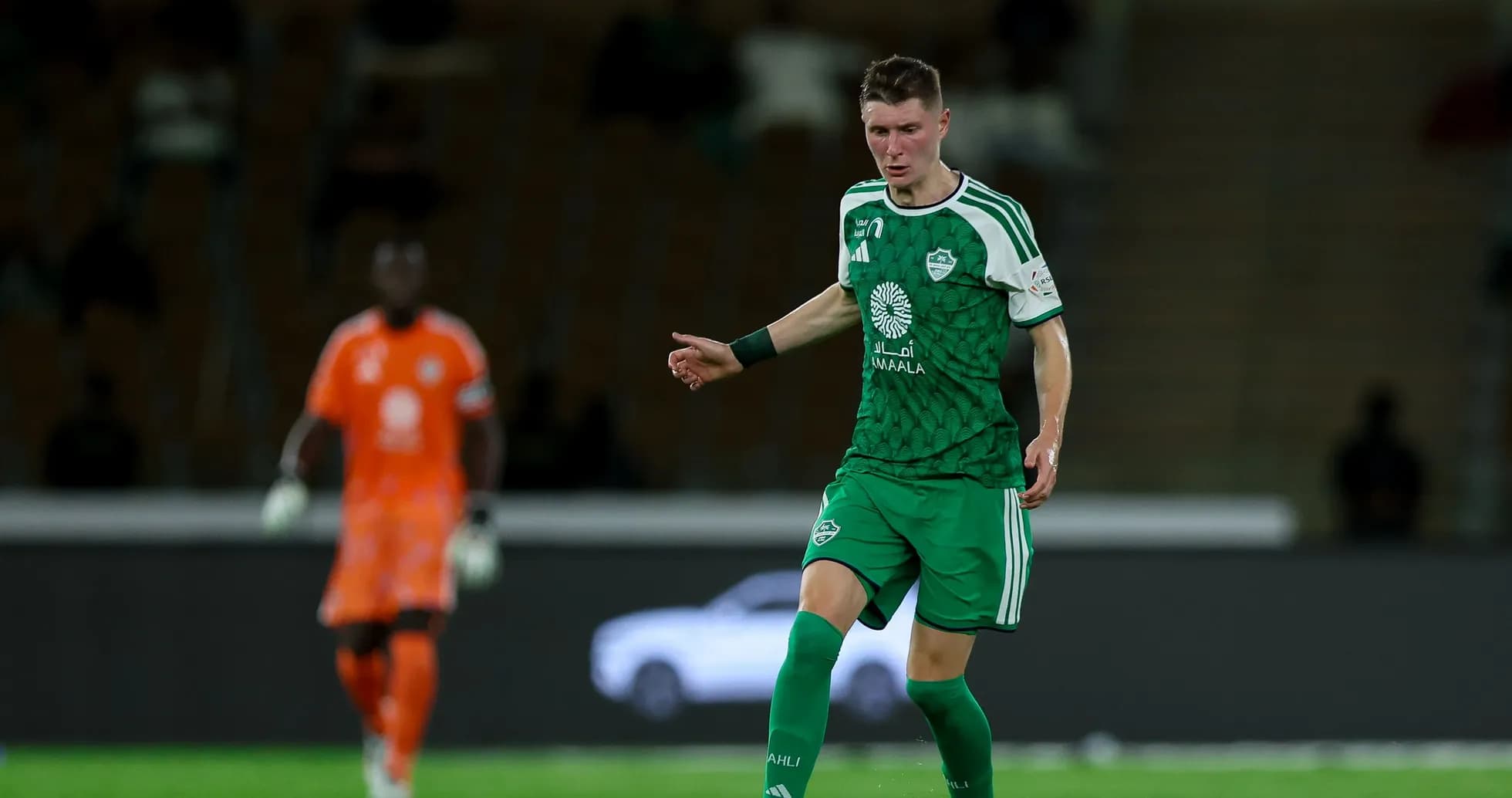 Joueur en maillot vert dribblant sur le terrain Joueur en maillot vert dribblant sur le terrain