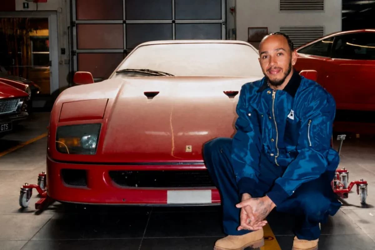 Homme posant devant une Ferrari rouge dans un garage Homme posant devant une Ferrari rouge dans un garage