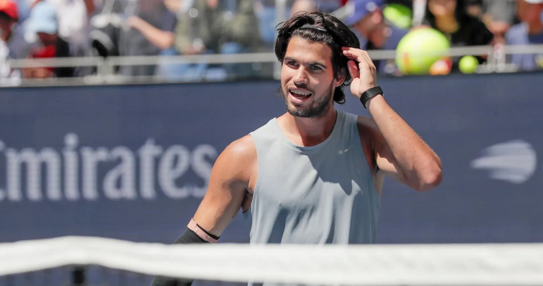 Joueur de tennis ajustant ses cheveux sur le court Joueur de tennis ajustant ses cheveux sur le court