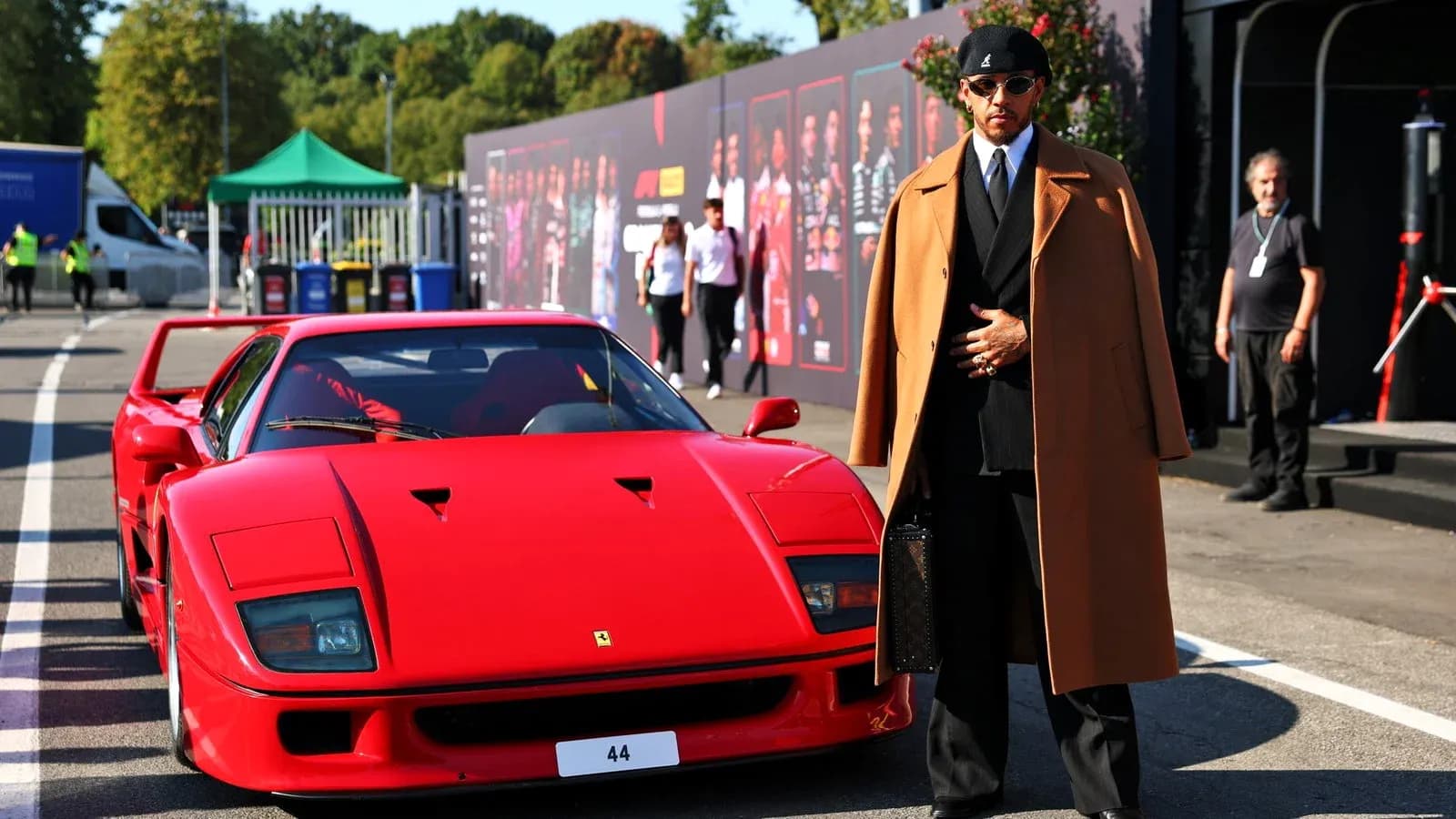 Homme en costume devant une Ferrari rouge Homme en costume devant une Ferrari rouge
