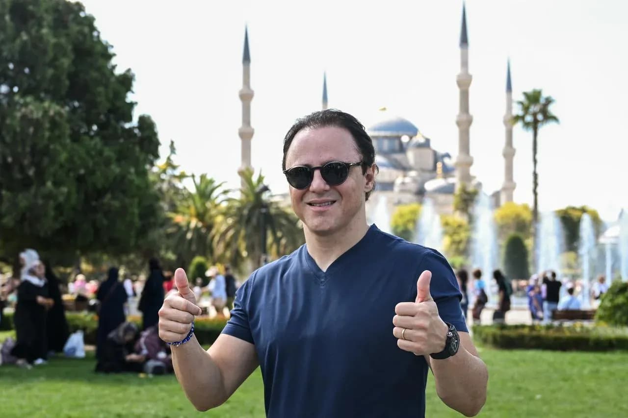 Homme faisant un pouce en l'air devant une mosquée Homme faisant un pouce en l'air devant une mosquée