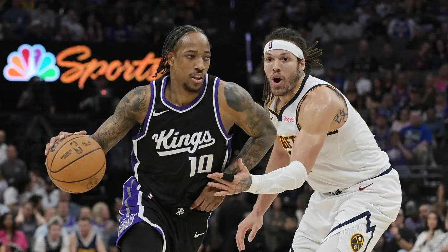 Joueur des Kings dribblant face à un défenseur des Nuggets Joueur des Kings dribblant face à un défenseur des Nuggets