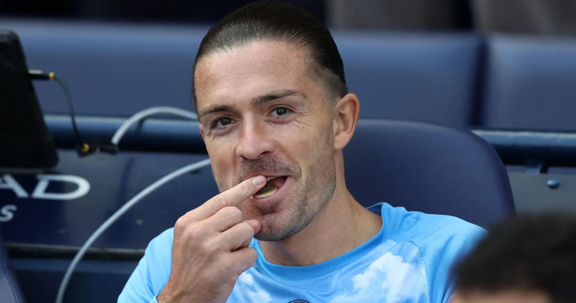 Joueur assis sur le banc, mangeant un bonbon Joueur assis sur le banc, mangeant un bonbon