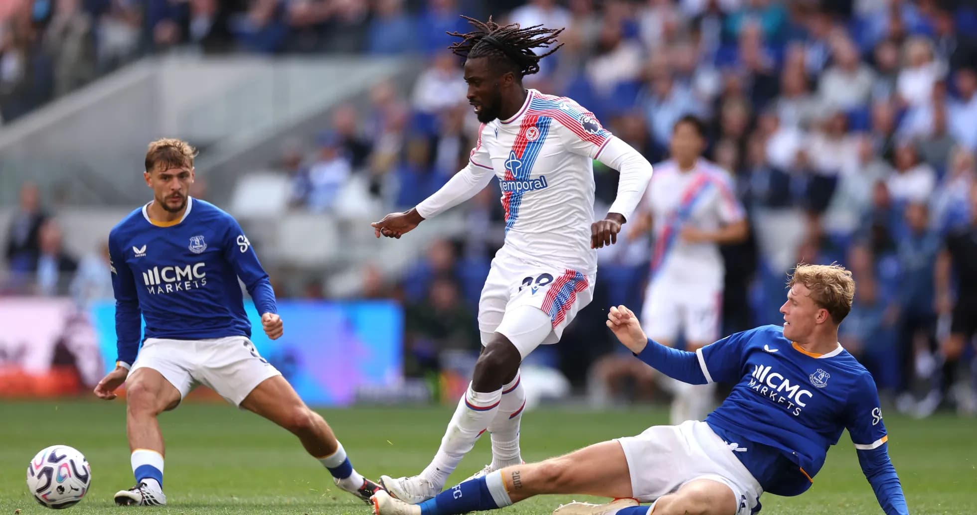 Joueur de Crystal Palace dribble entre deux joueurs d'Everton Joueur de Crystal Palace dribble entre deux joueurs d'Everton