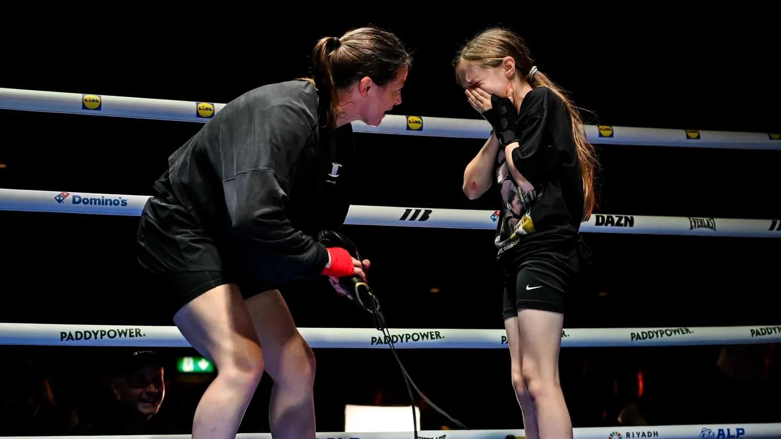 Boxeuse discutant avec une jeune fille sur le ring Boxeuse discutant avec une jeune fille sur le ring