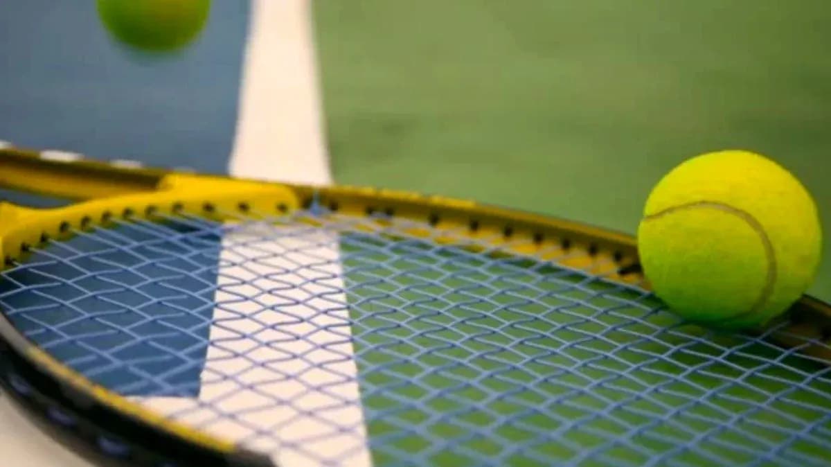 Balle de tennis sur une raquette sur le court Balle de tennis sur une raquette sur le court