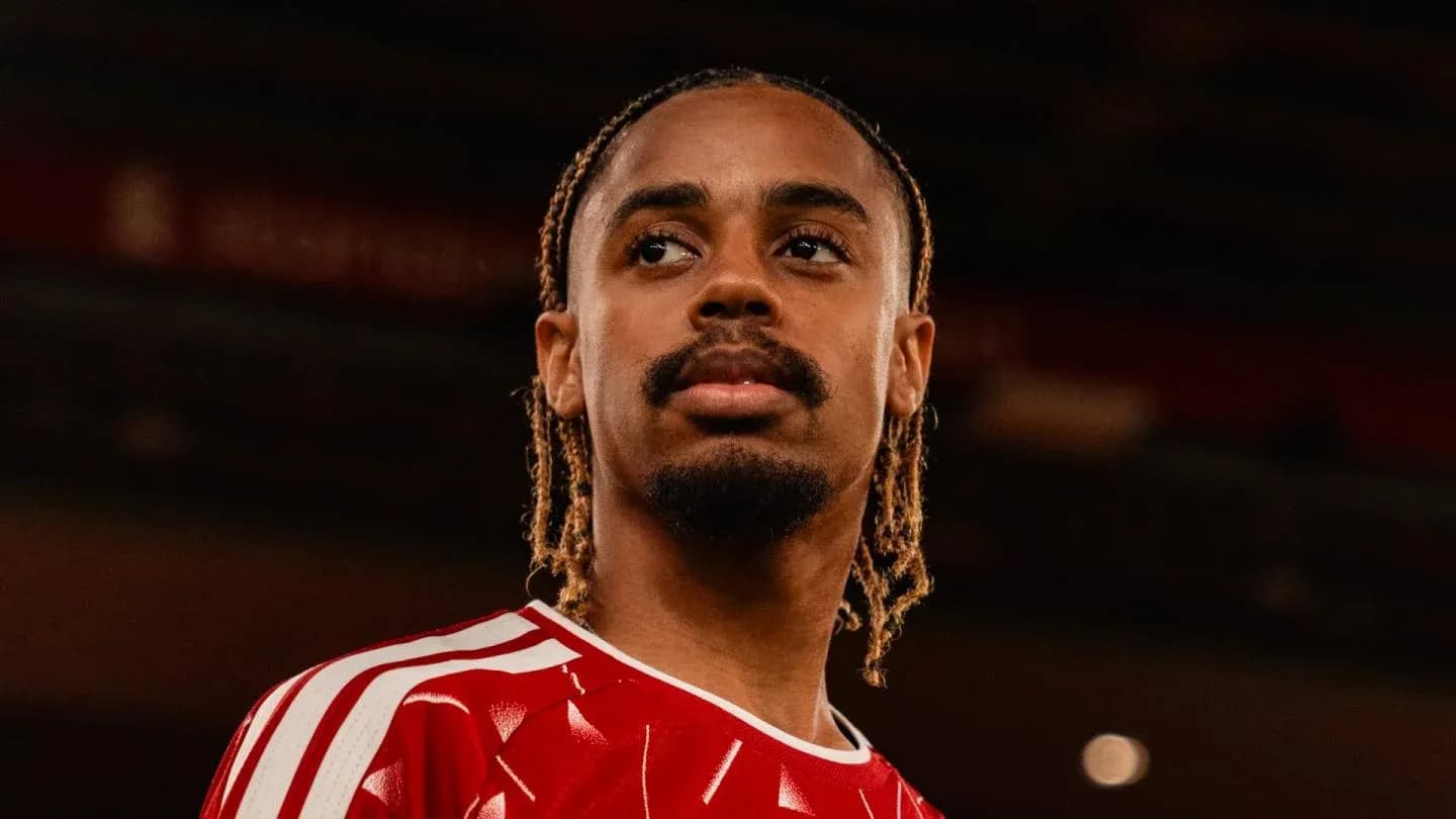 Joueur en maillot rouge, regard sérieux dans le stade Joueur en maillot rouge, regard sérieux dans le stade