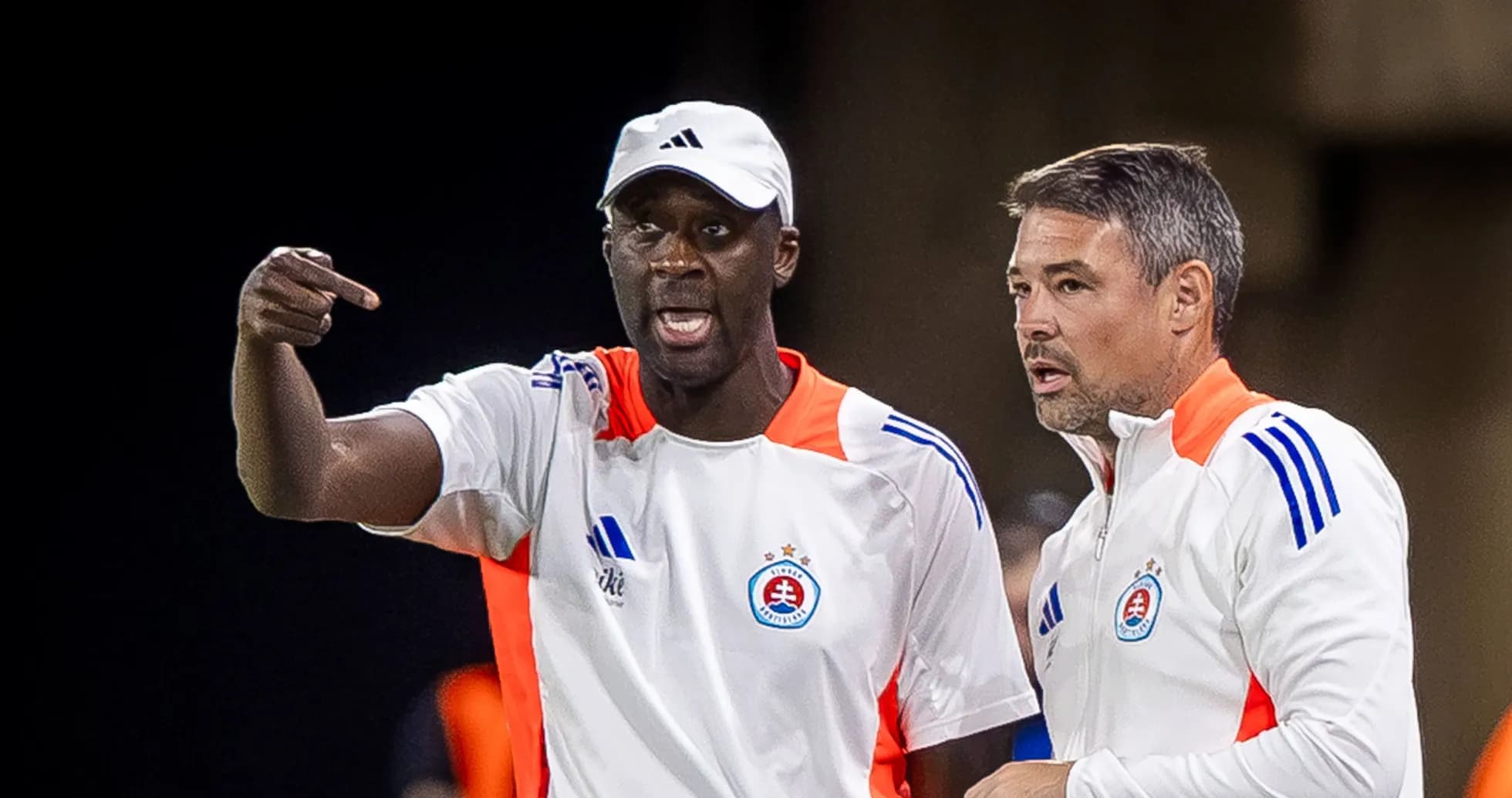 Deux entraîneurs discutant sur le banc de touche Deux entraîneurs discutant sur le banc de touche