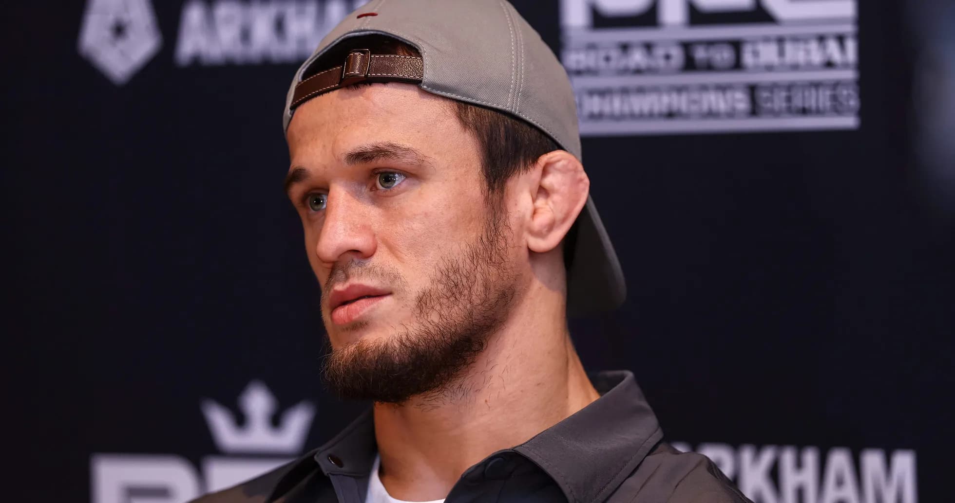 Athlete at press conference wearing cap and jacket Athlete at press conference wearing cap and jacket