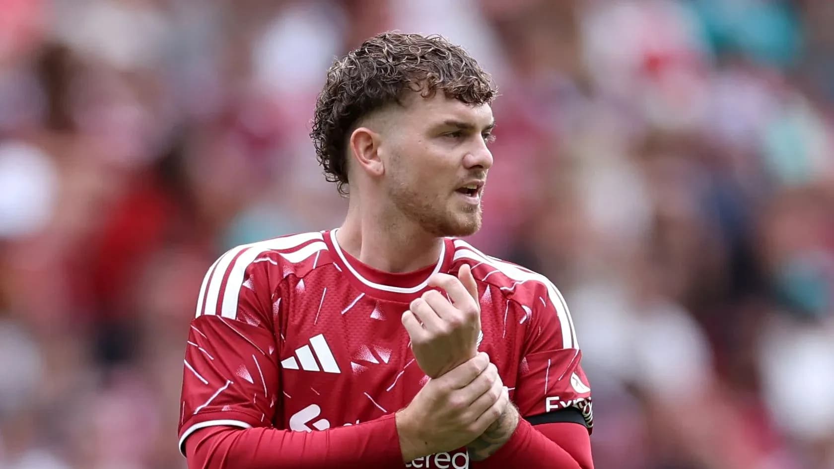 Joueur en maillot rouge ajustant son poignet Joueur en maillot rouge ajustant son poignet