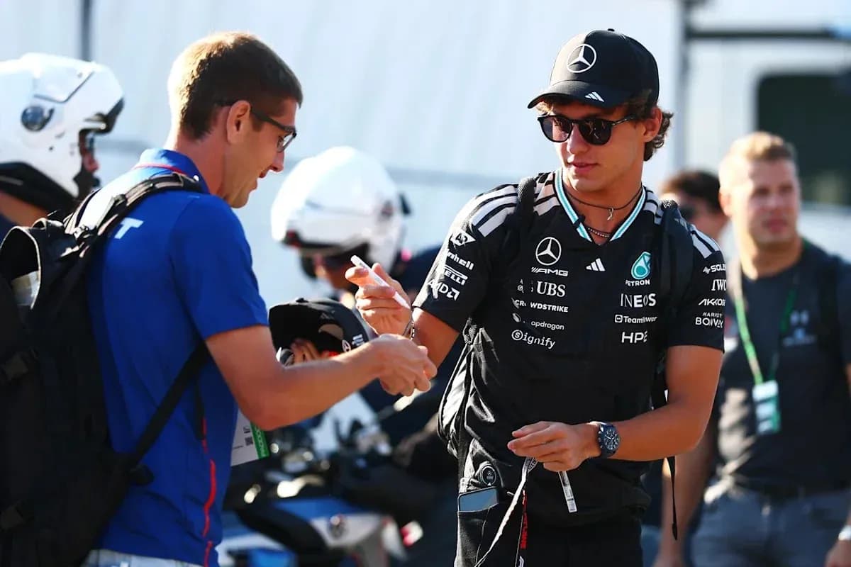 Pilote de F1 signant un autographe pour un fan Pilote de F1 signant un autographe pour un fan