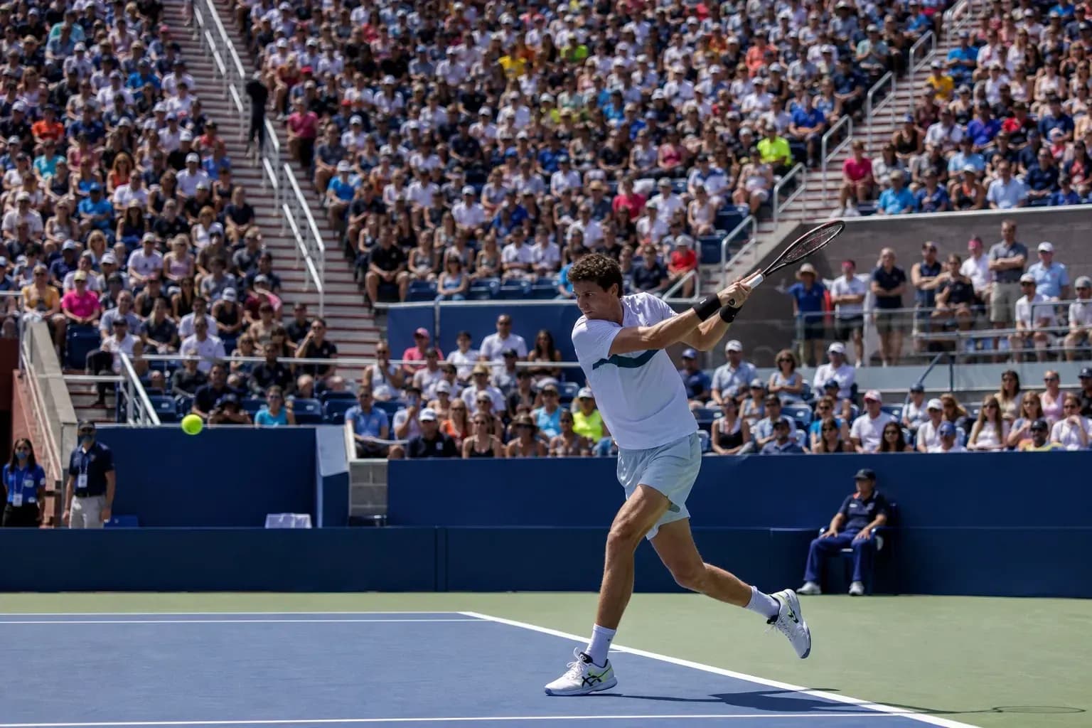 Joueur de tennis frappant une balle devant un public Joueur de tennis frappant une balle devant un public