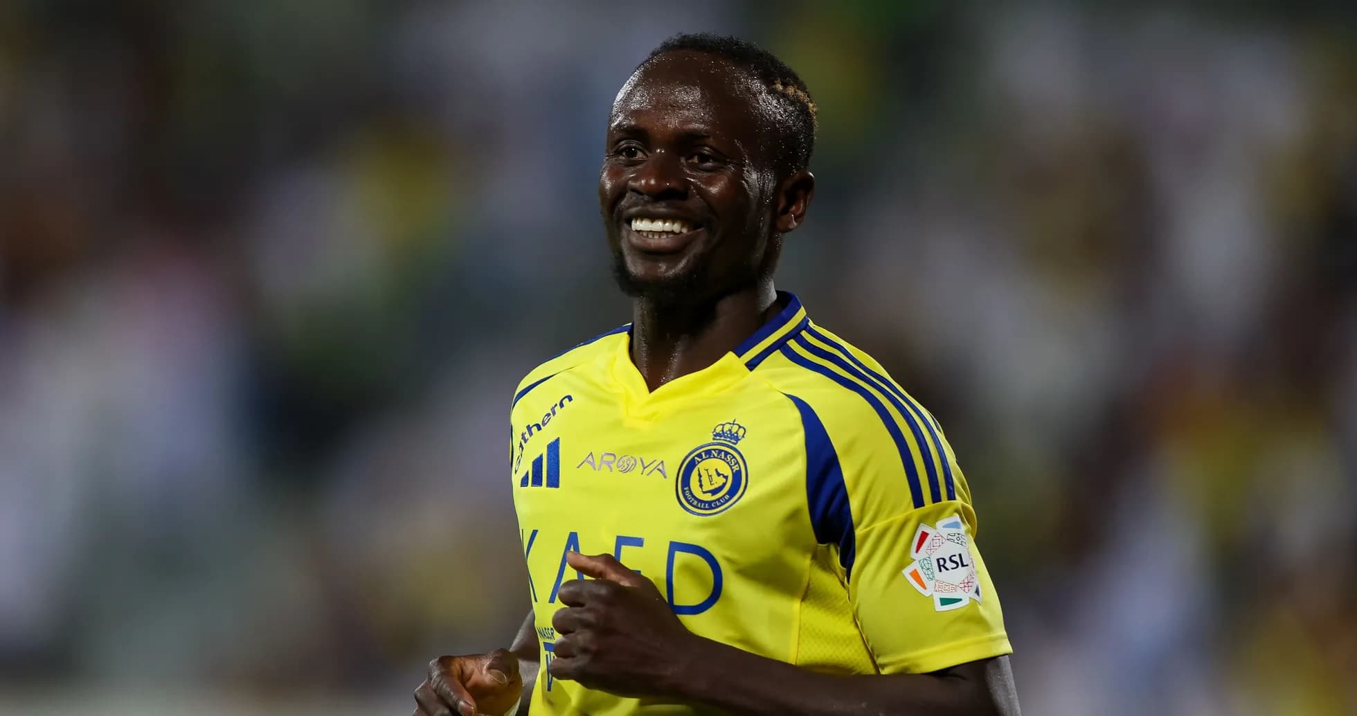 Joueur souriant en maillot d'Al Nassr sur le terrain Joueur souriant en maillot d'Al Nassr sur le terrain