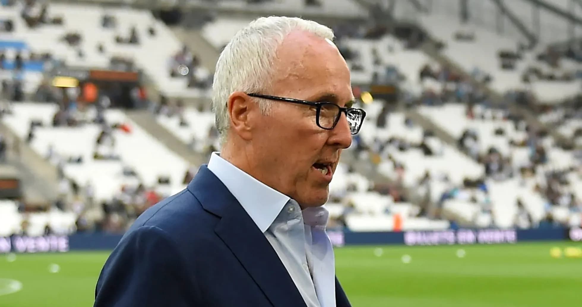 Homme en costume parlant sur le terrain de football Homme en costume parlant sur le terrain de football