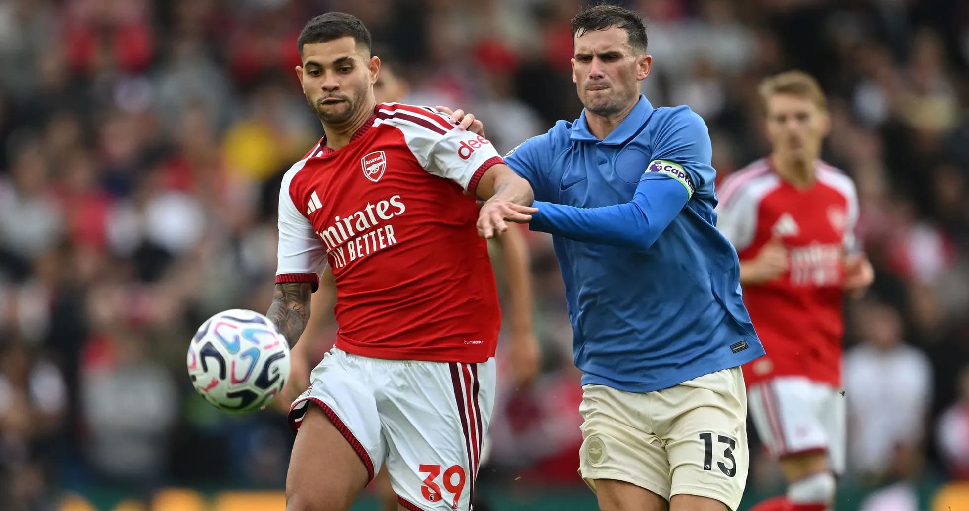 Joueur d'Arsenal dribblant sous la pression adverse Joueur d'Arsenal dribblant sous la pression adverse