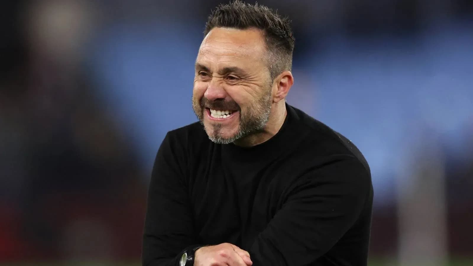 Entraîneur souriant sur le terrain après le match Entraîneur souriant sur le terrain après le match