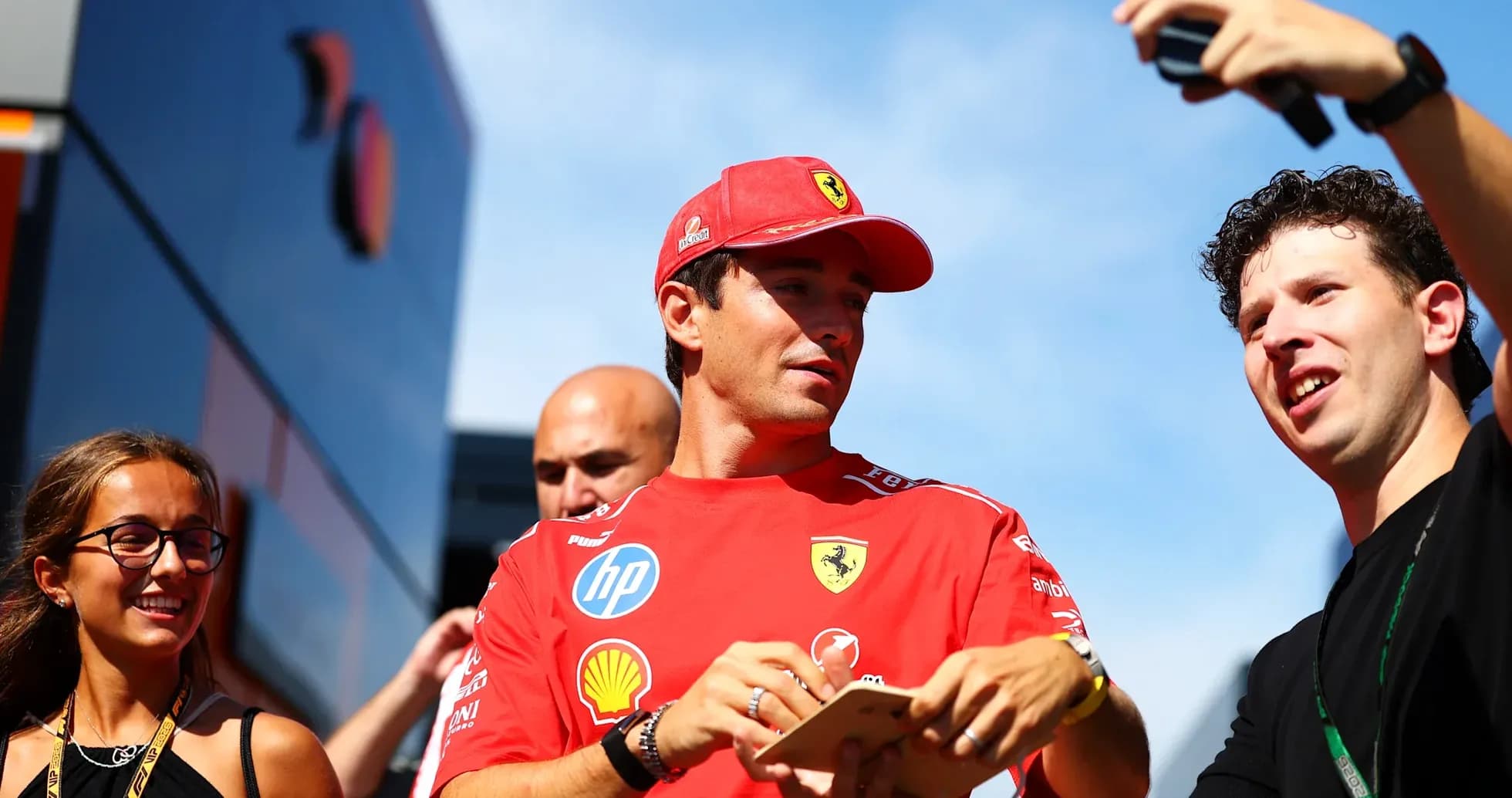Pilote Ferrari interagissant avec des fans lors d'un événement Pilote Ferrari interagissant avec des fans lors d'un événement