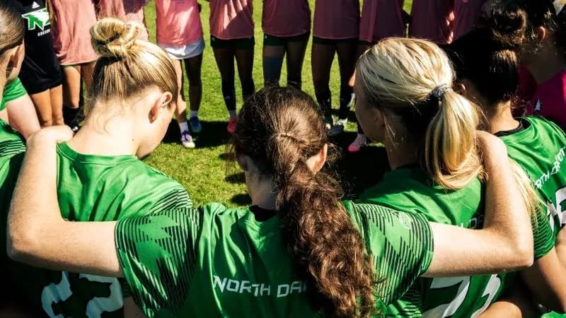 Joueuses de football formant un cercle avant l'entraînement Joueuses de football formant un cercle avant l'entraînement