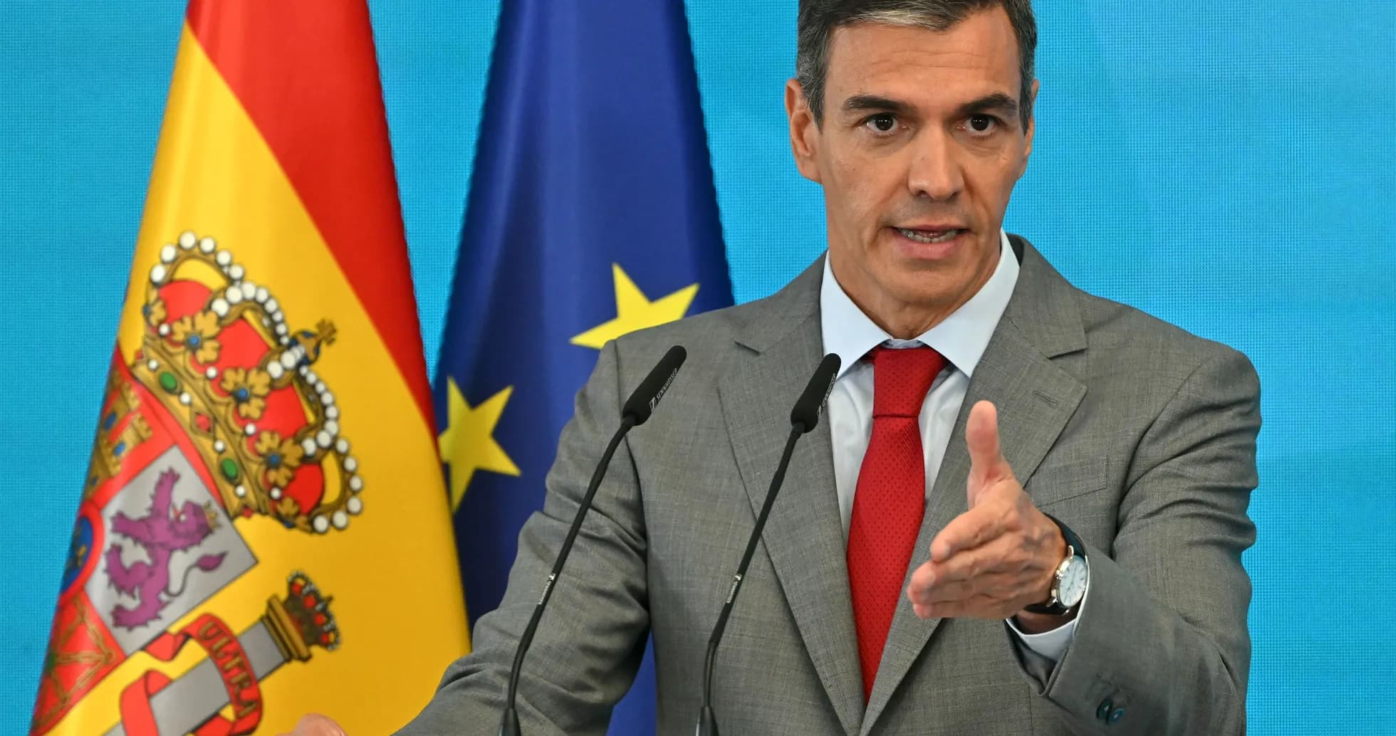 Homme parlant à un podium avec drapeaux derrière Homme parlant à un podium avec drapeaux derrière