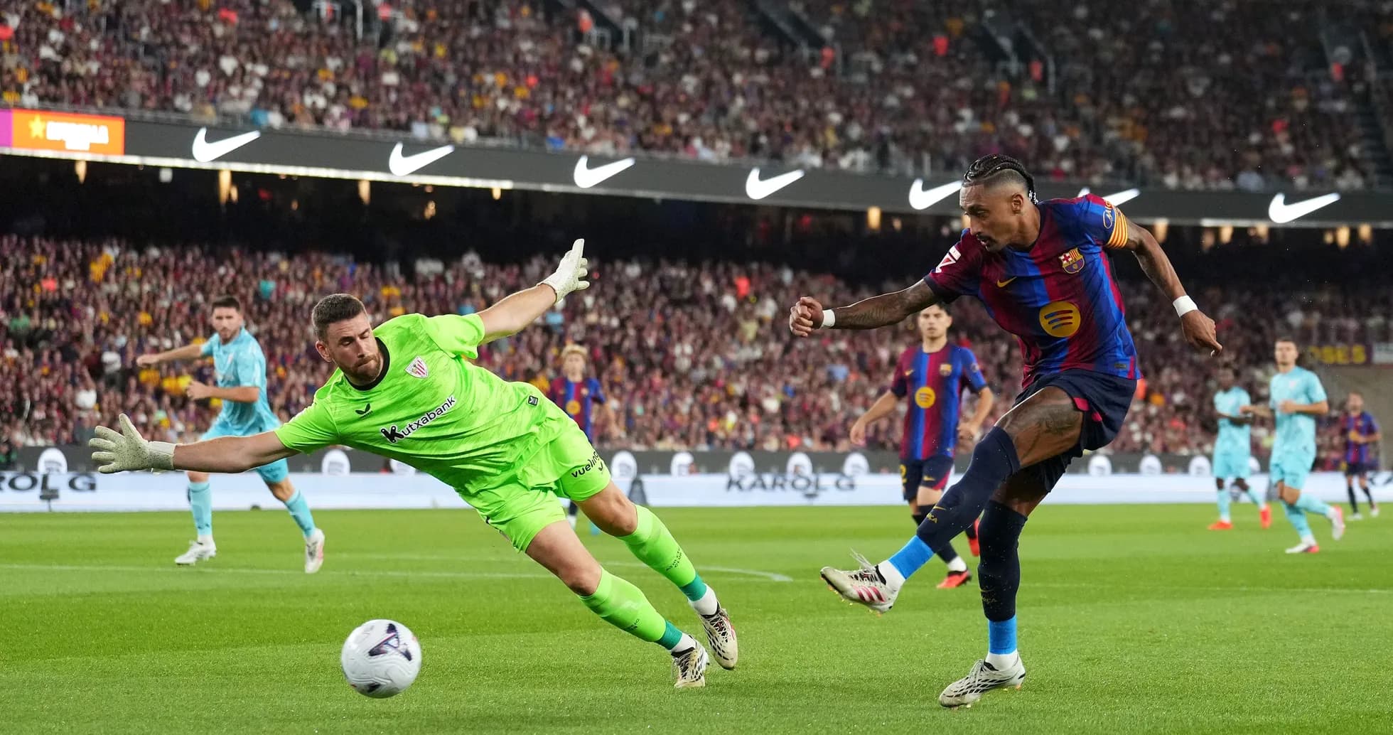 Joueur du Barça tirant au but, gardien plongeant Joueur du Barça tirant au but, gardien plongeant