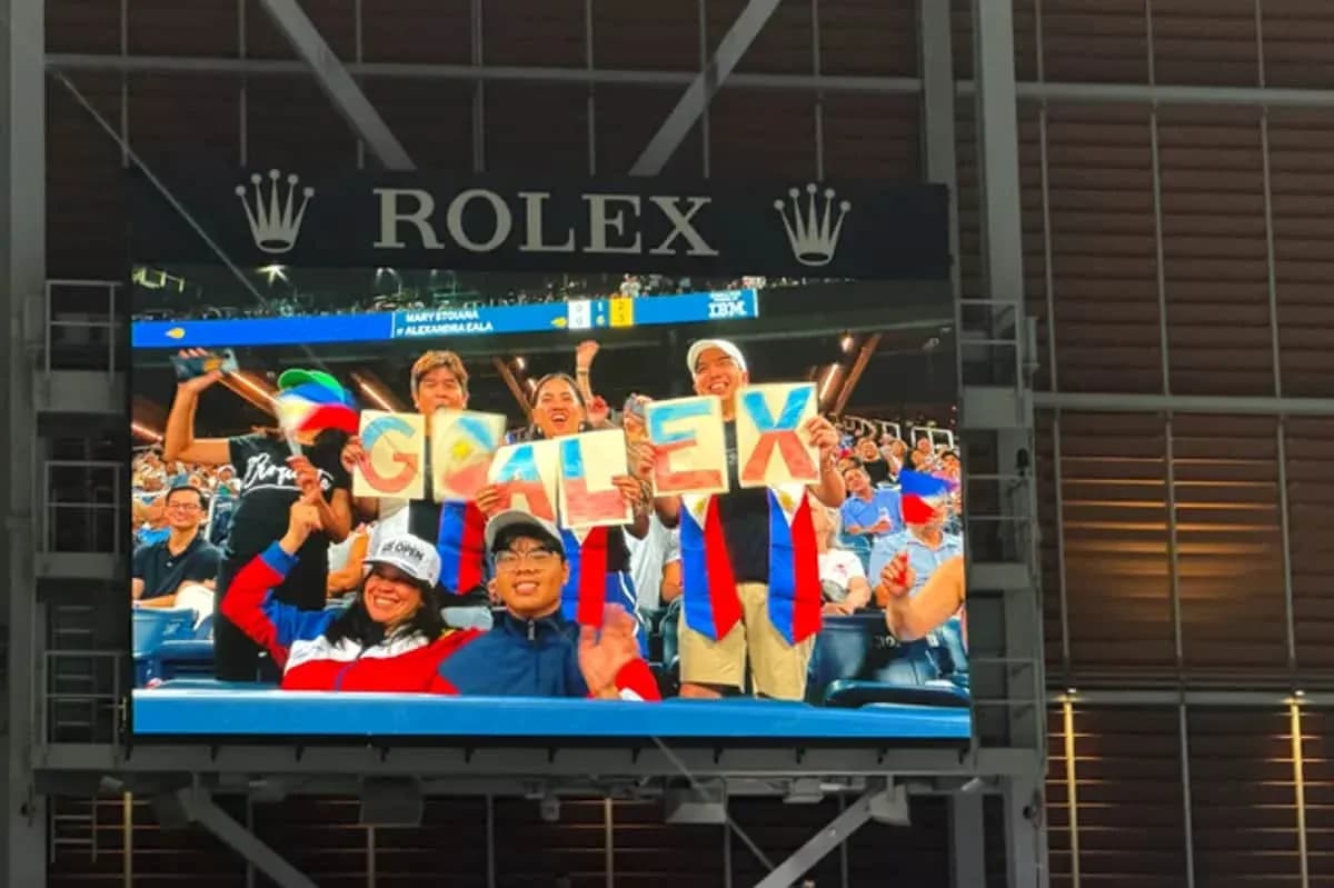 Supporters holding 'GO ALEX' sign at event Supporters holding 'GO ALEX' sign at event
