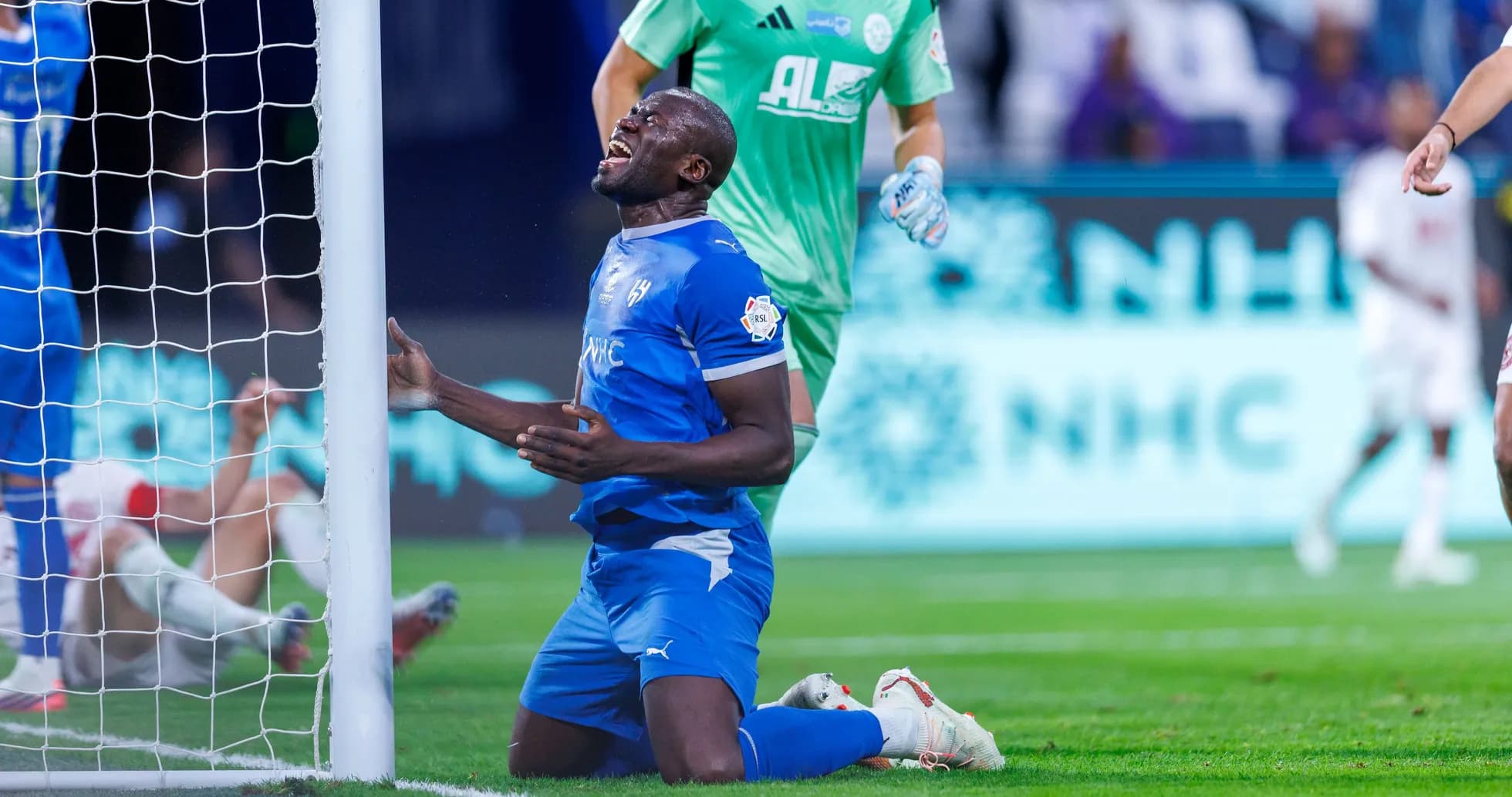 Joueur de football à genoux près du but Joueur de football à genoux près du but