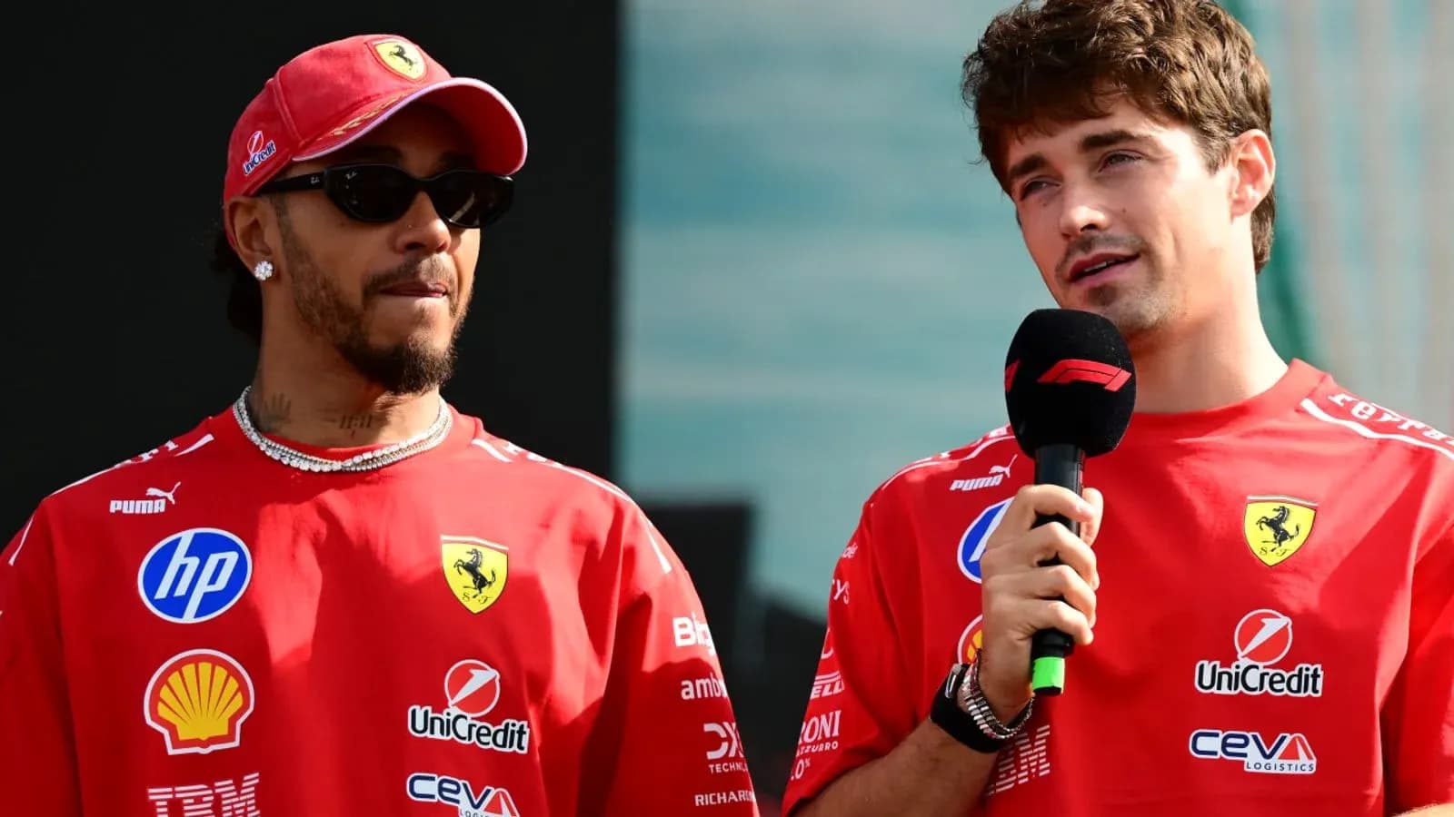 Deux pilotes de F1 en tenue Ferrari lors d'une conférence Deux pilotes de F1 en tenue Ferrari lors d'une conférence