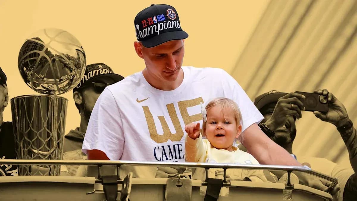 Joueur tenant un enfant près du trophée NBA Joueur tenant un enfant près du trophée NBA
