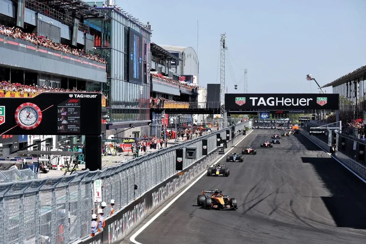 Voitures de F1 en course sur circuit avec public Voitures de F1 en course sur circuit avec public