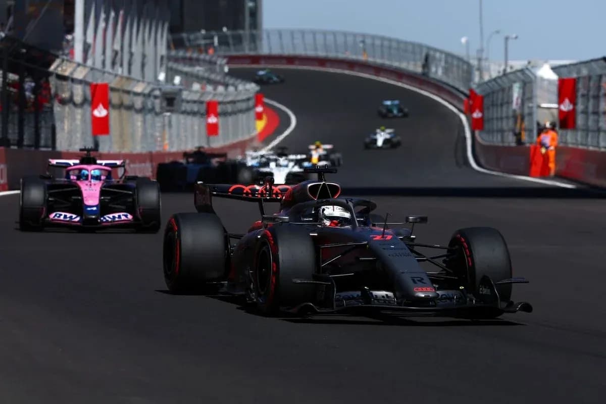 Voiture de course en tête sur circuit, autres derrière Voiture de course en tête sur circuit, autres derrière