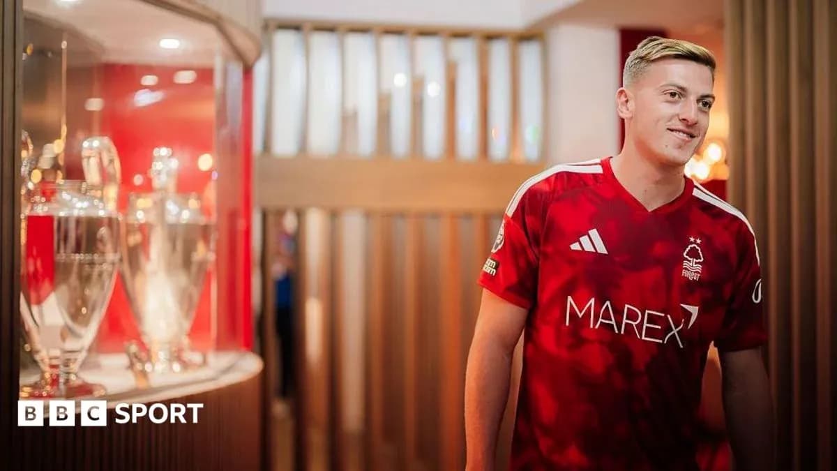 Joueur en maillot de Nottingham Forest près des trophées Joueur en maillot de Nottingham Forest près des trophées