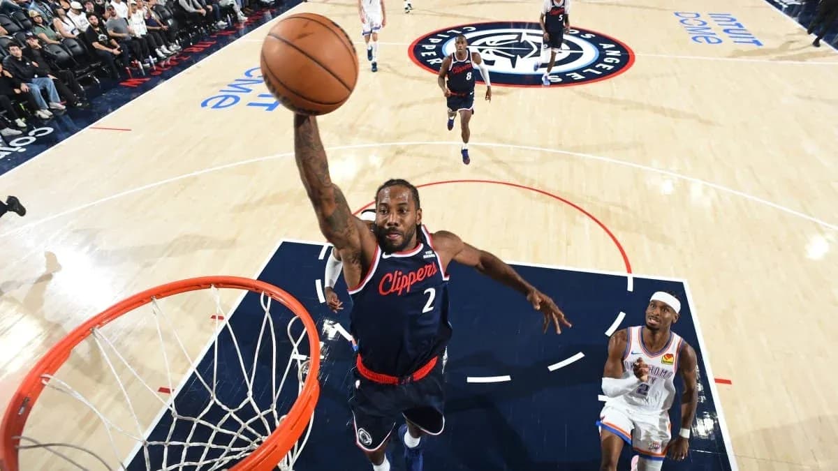 Joueur des Clippers dunkant au-dessus d'un adversaire Joueur des Clippers dunkant au-dessus d'un adversaire