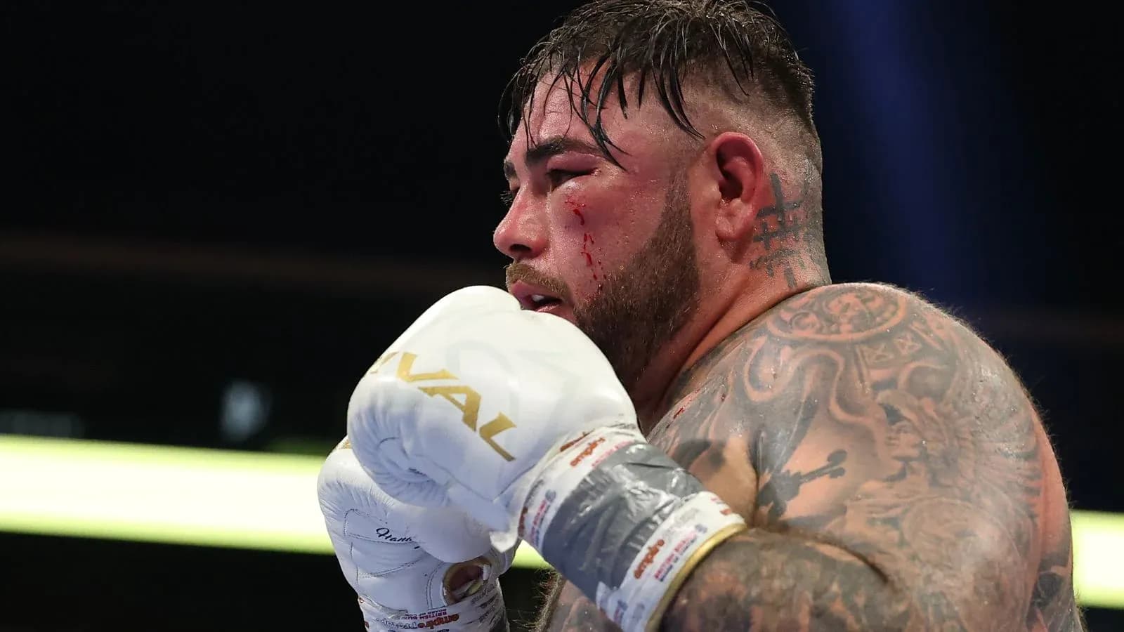 Boxeur avec des gants, visage ensanglanté durant le combat Boxeur avec des gants, visage ensanglanté durant le combat